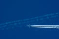 Transportation competition concept: a jet airplane crossing other planeÃ¢â¬â¢s white contrail against blue sky background Royalty Free Stock Photo